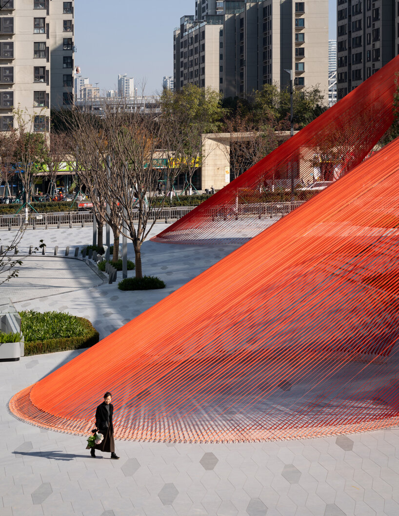 behin ha weaves temporary installation with orange mesh fabric ribbons at hangzhou complex