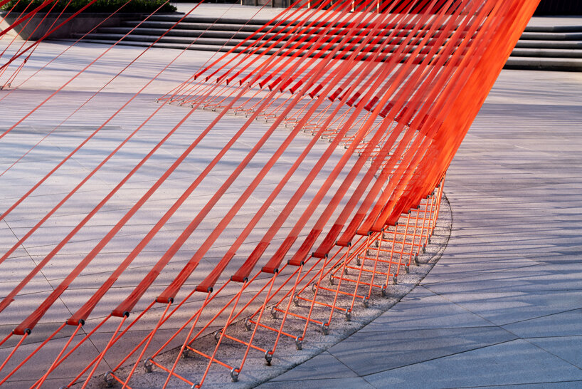 behin ha weaves temporary installation with orange mesh fabric ribbons at hangzhou complex