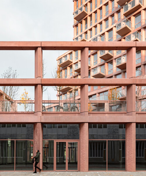 a dynamic colonnade enwraps studioninedots' mixed-use red concrete tower in almere