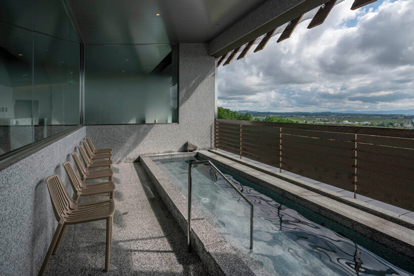 kengo kuma cloaks hot spring resort in hokkaido with locally sourced larch wood