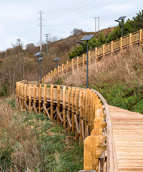pedestrian wooden walkway on stilts traces hillside in bilbao