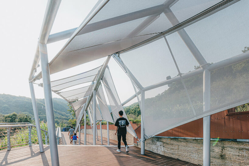 covered in sheer white mesh, this daydream trail station casts a poetic glow in coastal china