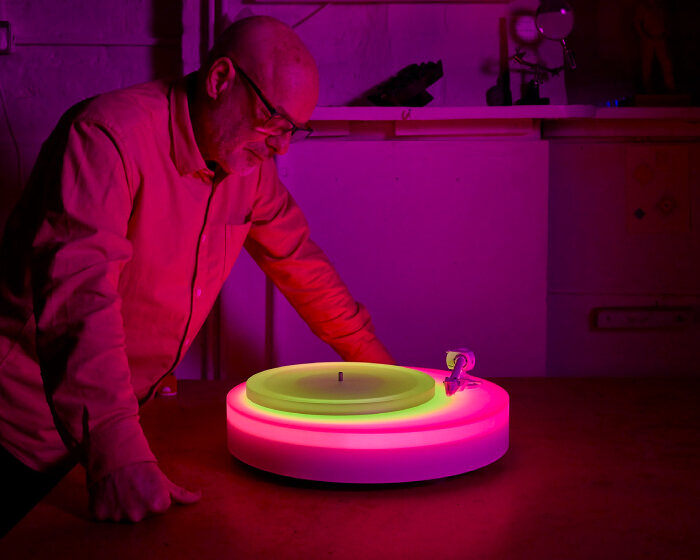 brian eno’s turntable II glows in different acrylic neon lights as the vinyl record plays