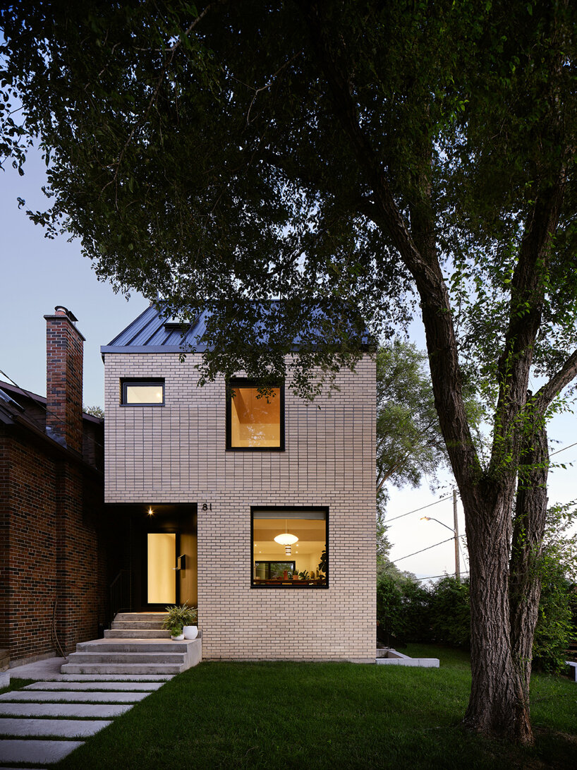 brick residence's sloping roof shields outdoor balcony in toronto