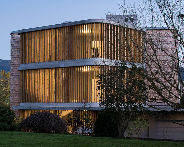 comamala ismail clothes residence's concrete structure with split fir shingles in switzerland