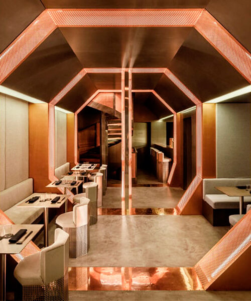 metallic octagonal portals outline the dynamic interior of omasake bar in paris