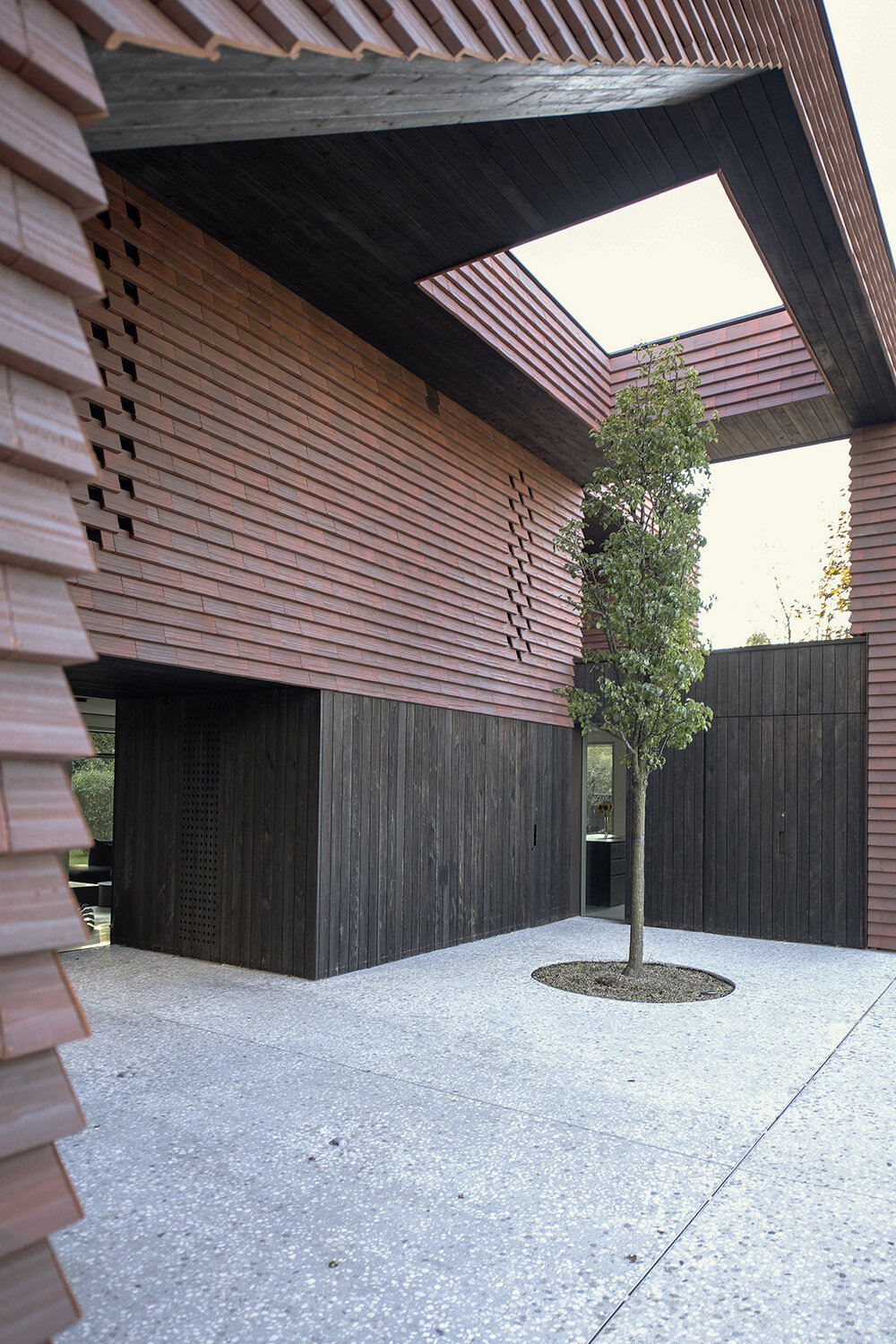 Brick canopy doubles as playground for OFIS Architects' frame house in Slovenia