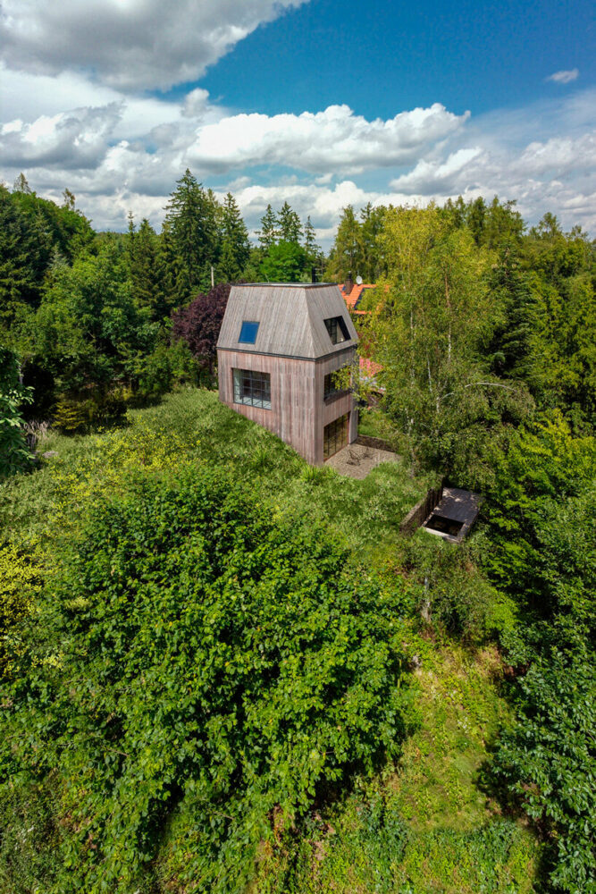 timber-clad cottage jaro by edit! interacts with forest sloping site in the czech republic