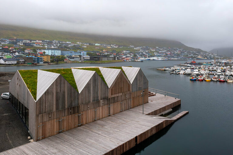 henning larsen's klaksvík row club backdropped by faroe islands' fjords