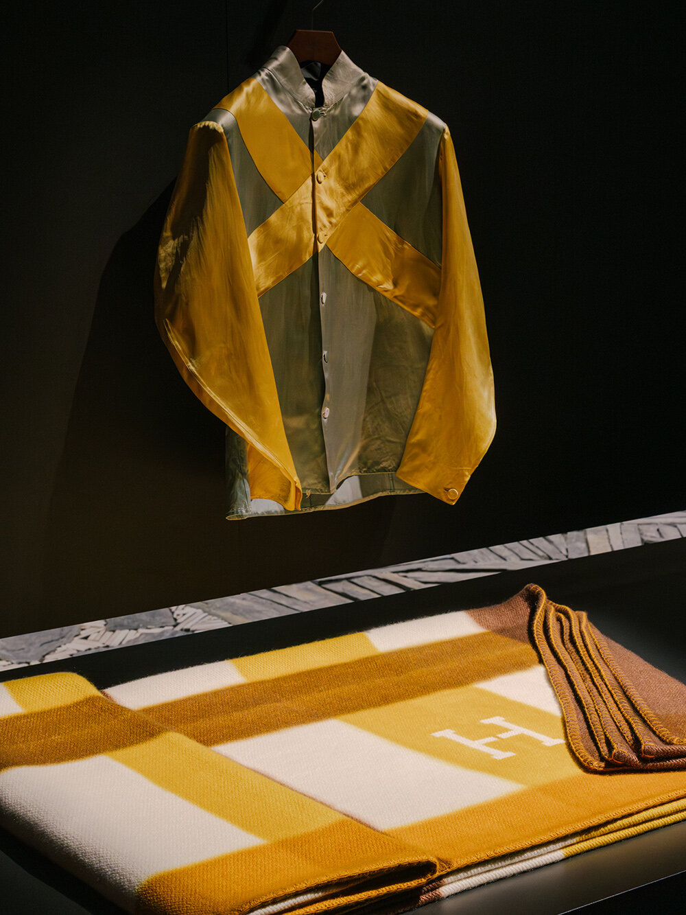 Hermès depicts a jockey’s silk jersey using brick, stone, wood & earth at milan design week