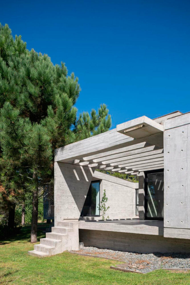 casa tres' exposed concrete volume by estudio galera floats above steep slope in argentina
