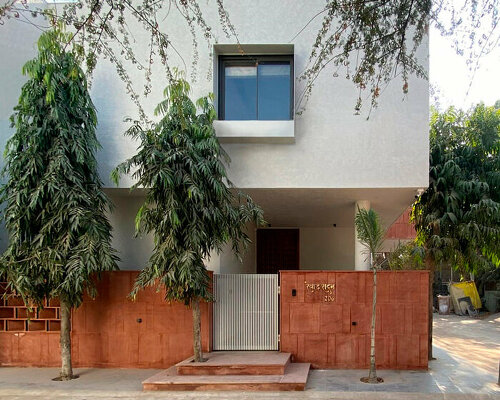 light-filled earthy colored home is cocooned in lush green garden in india