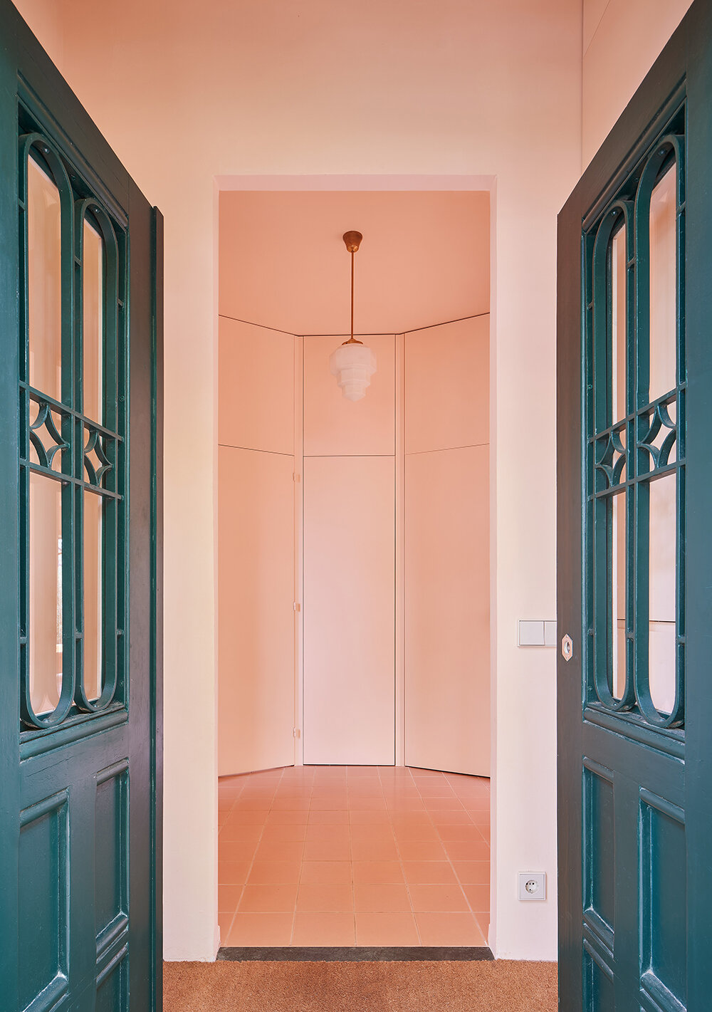 a light peach tone engulfs every corner of this two-family house in barcelona
