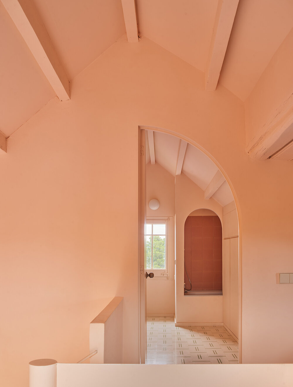 a light peach tone engulfs every corner of this two-family house in barcelona