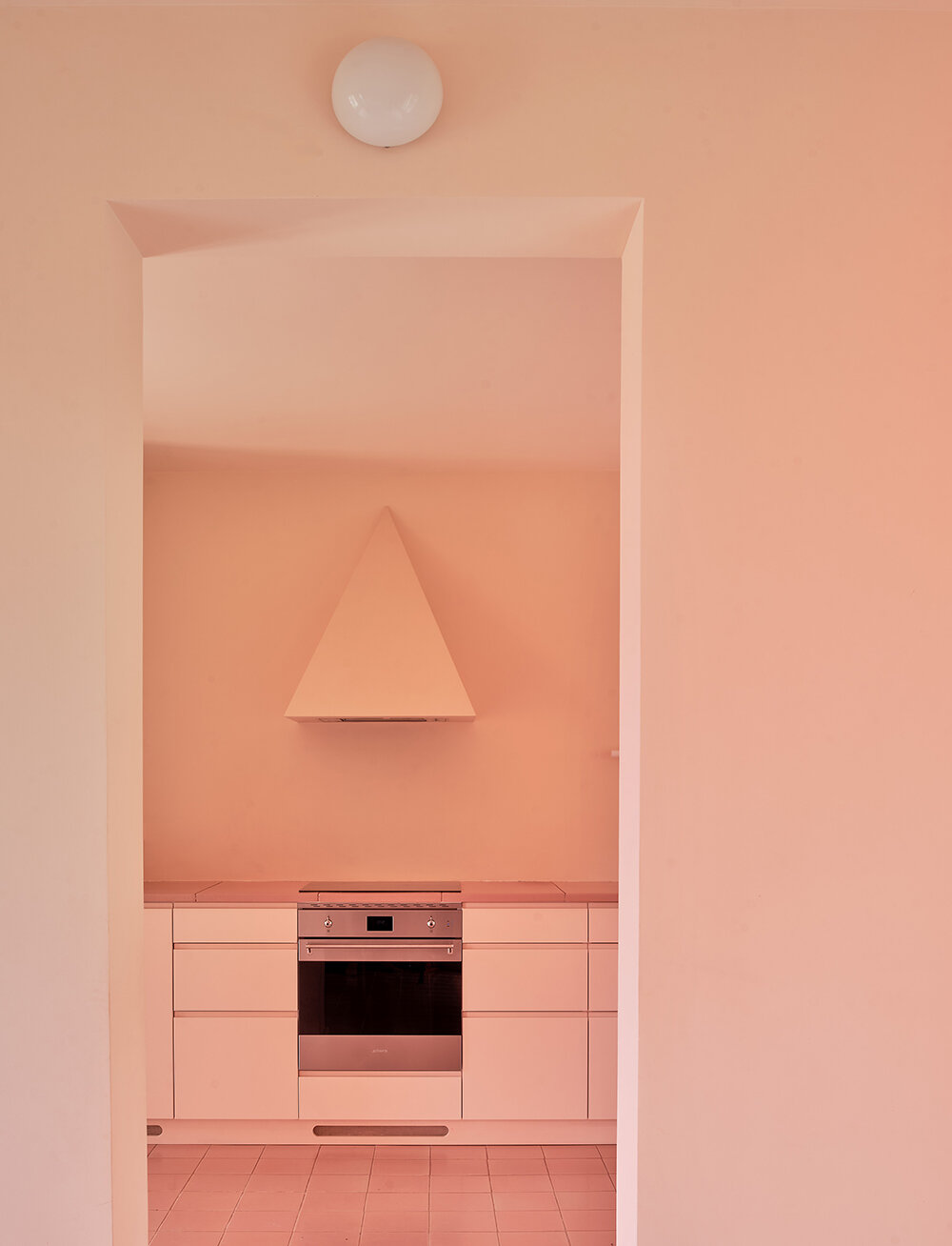 a light peach tone engulfs every corner of this two-family house in barcelona