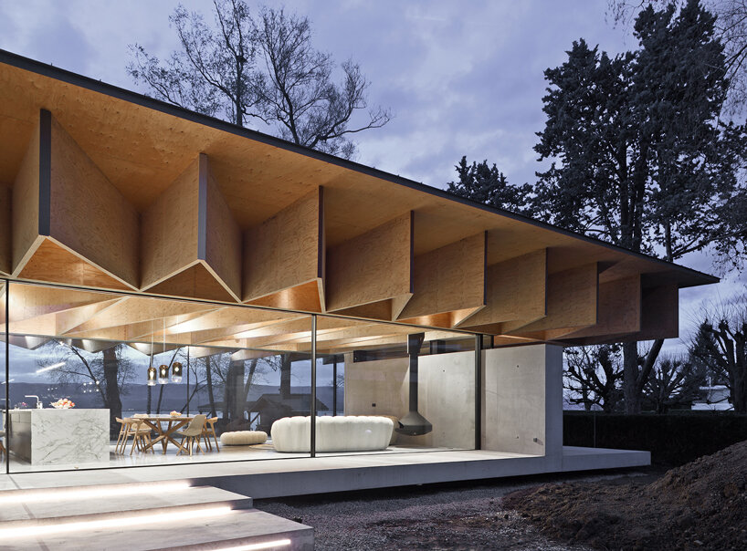Paneles de madera tipo origami se despliegan sobre la casa Bachholz en el lago de Ginebra