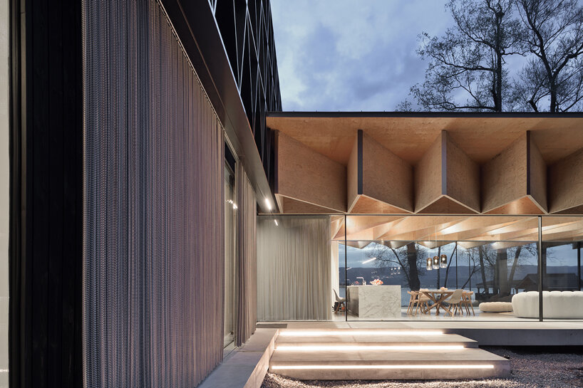Paneles de madera tipo origami se despliegan sobre la casa Bachholz en el lago de Ginebra
