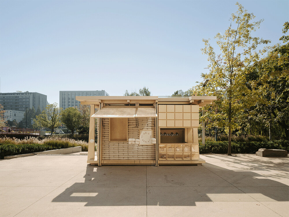 F.O.G. fronts cycle cycle mobile bakehouse with piles of grain sacks