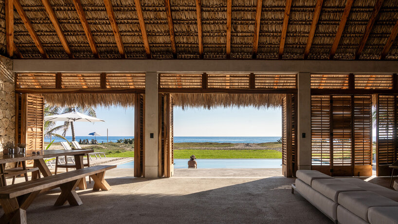 stone walls and palm-thatched palapas blend tate house into the oaxacan landscape