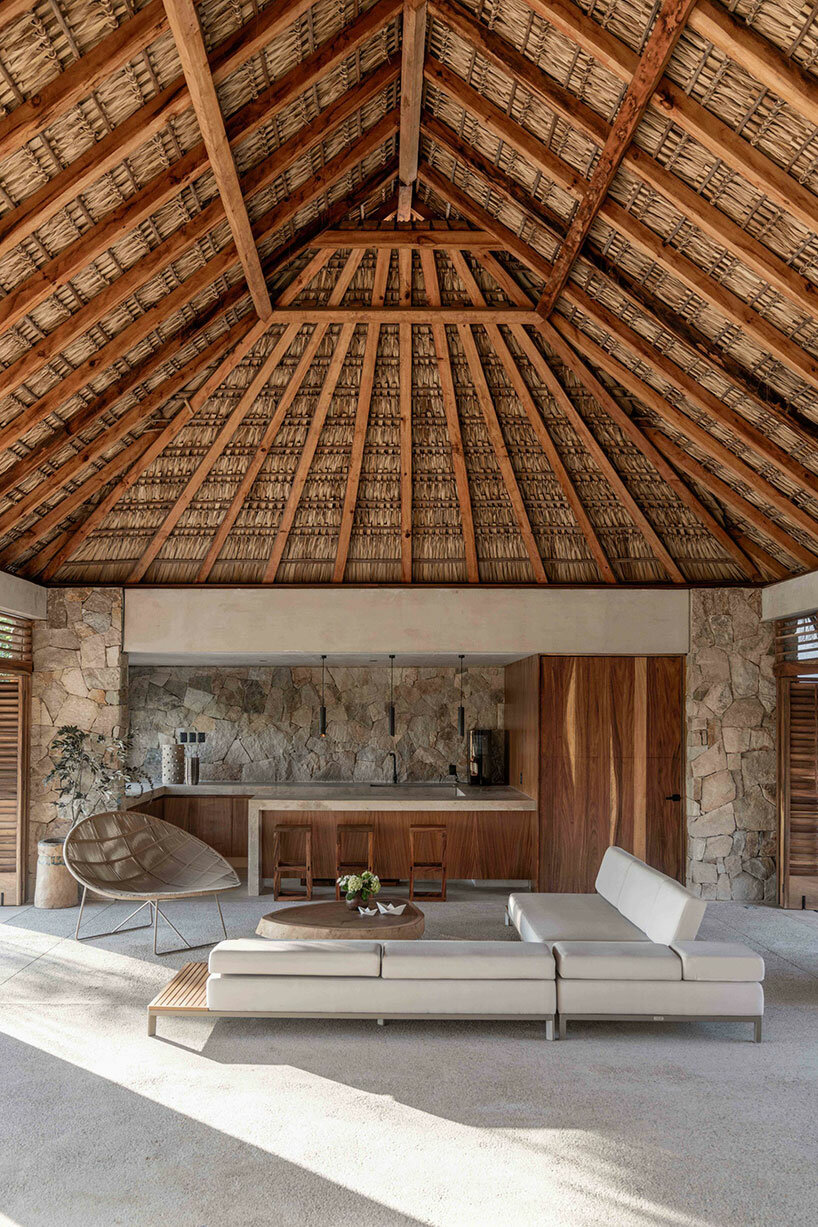 stone walls and palm-thatched palapas blend tate house into the oaxacan landscape