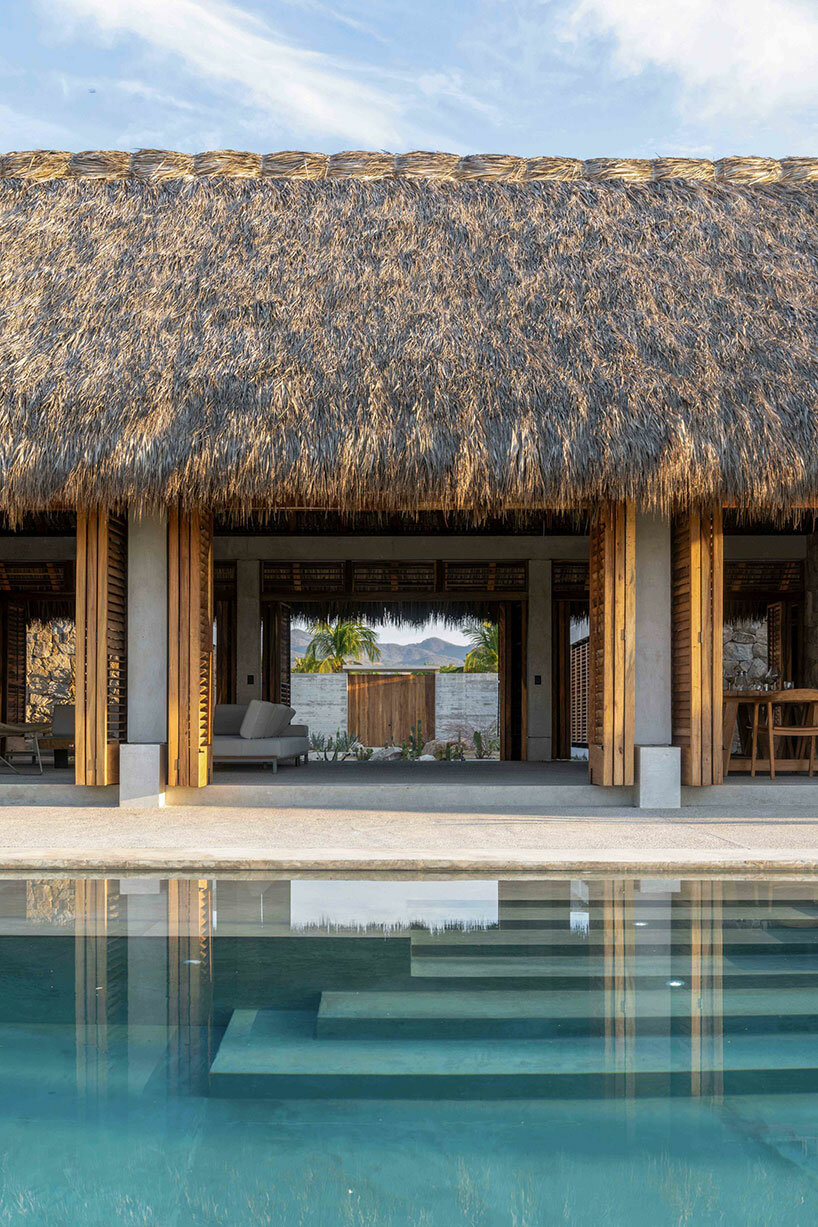 stone walls and palm-thatched palapas blend tate house into the oaxacan landscape