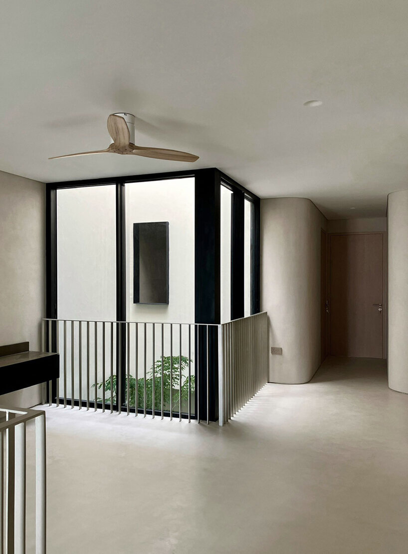 fluid facade envelops all-white monolithic curlicue house in singapore