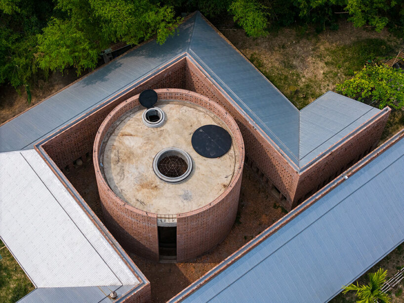 circular and folded brick walls envelop tropical space's terra cotta workshop in vietnam