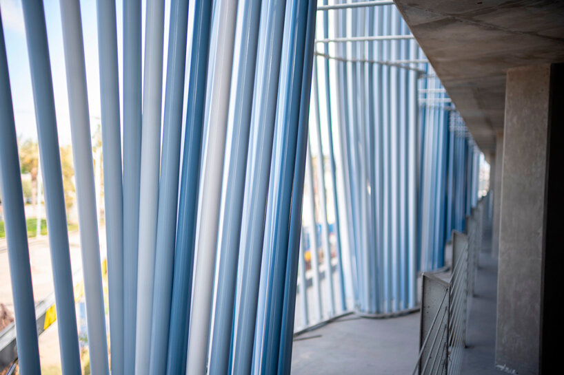 hundreds of aluminum tubes undulate shaping 'ensemble' installation by rob ley