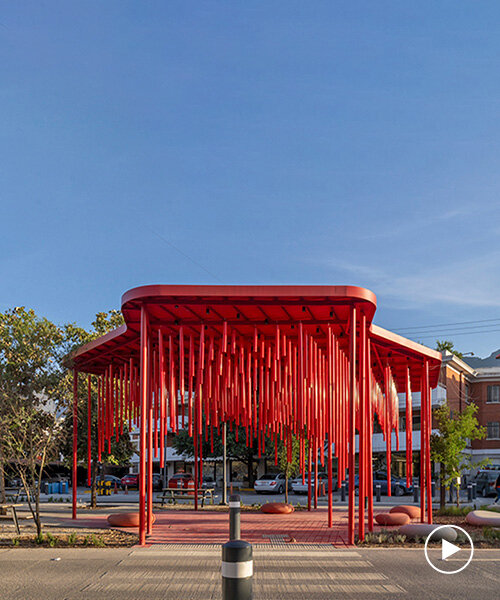 melodic tubes sway in the wind, inviting pedestrians to vibrant red pavilion in mexico