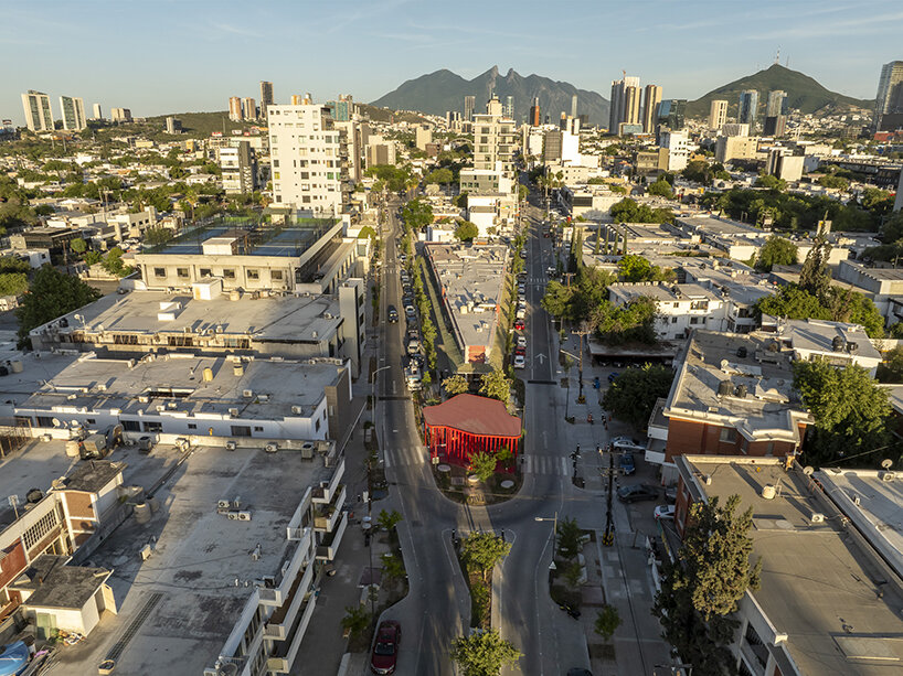 Tubos melódicos se mecen con el viento, invitando a los peatones al vibrante pabellón rojo en México.