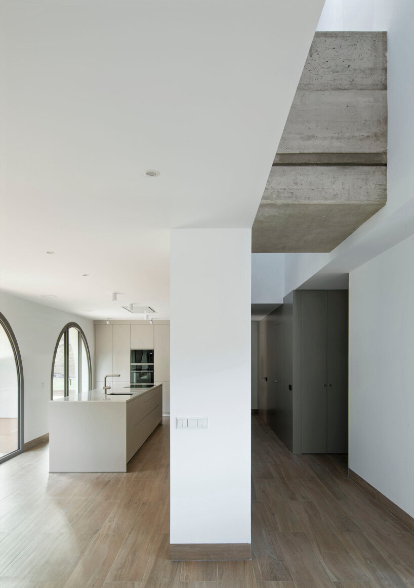 sculptural residence in spain emerges as an all-white monolith among tall pines