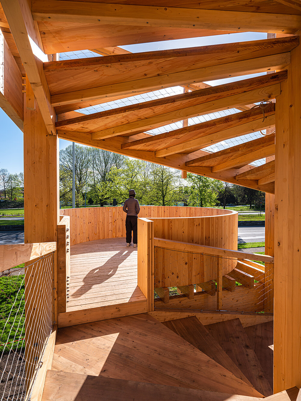 wooden 'tower of balance' by boonserm premthada emits ancient bell sounds across bruges