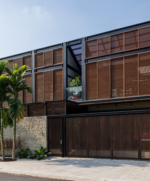 a+ architects' ecobreeze house self-breaths through wooden double-skin facade in vietnam