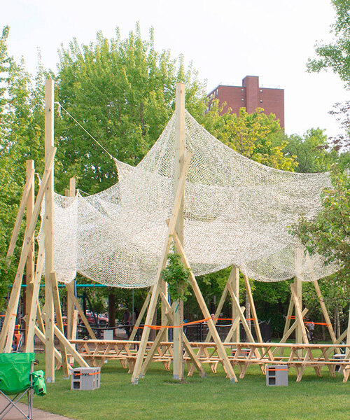 vanishing community room by alsar atelier uses tree stakes and textile canopies for shading