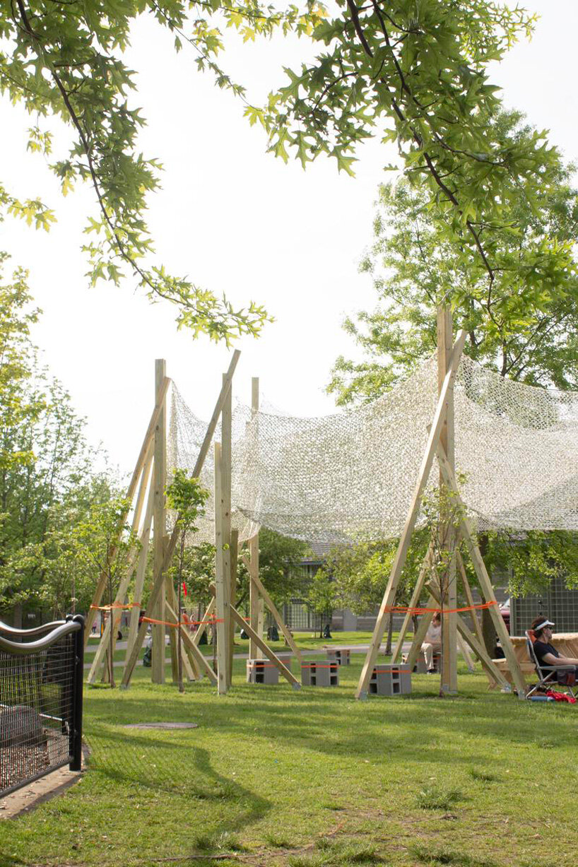 vanishing community room by alsar atelier uses tree stakes and textile canopies for shading