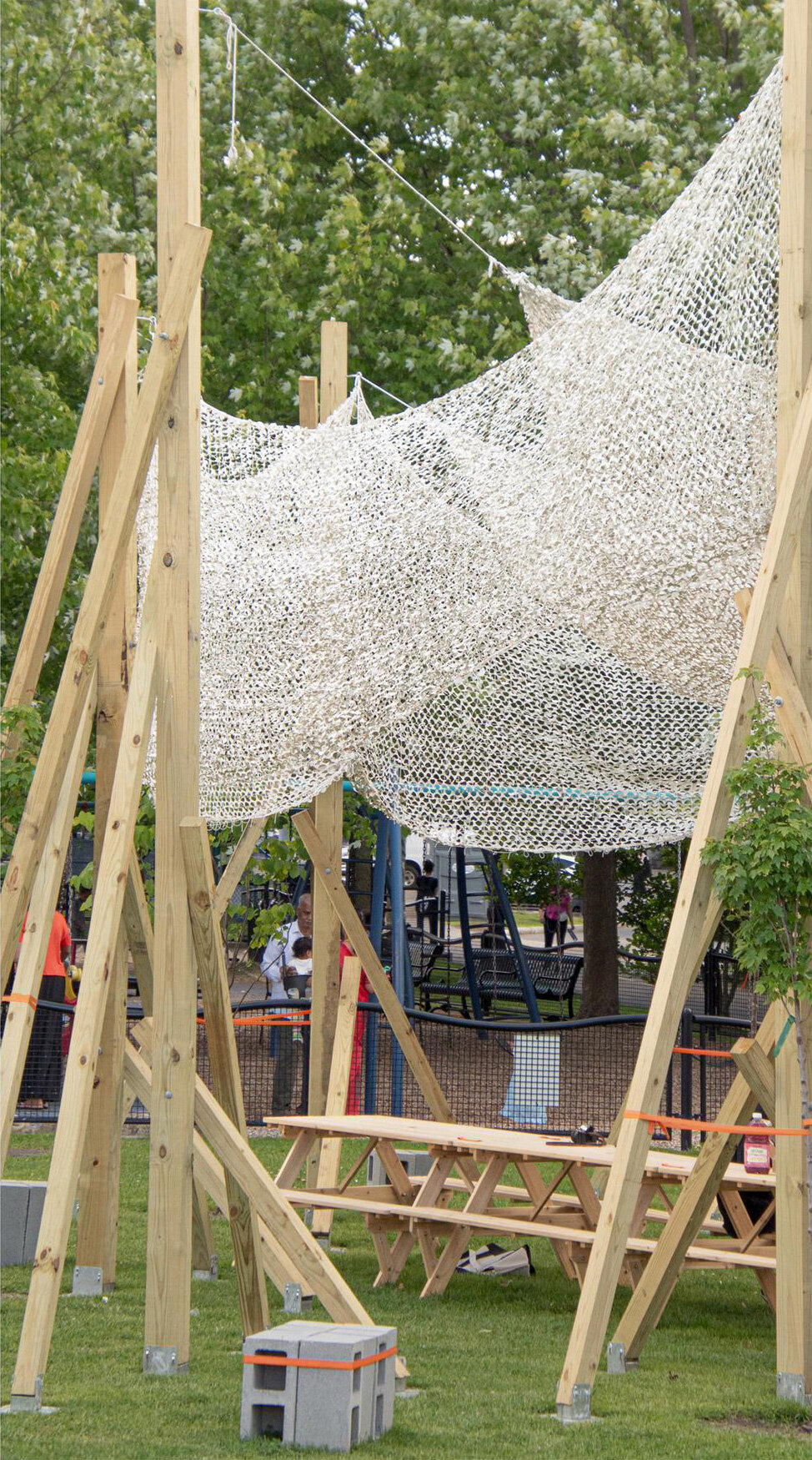 vanishing community room by alsar atelier uses tree stakes and textile canopies for shading