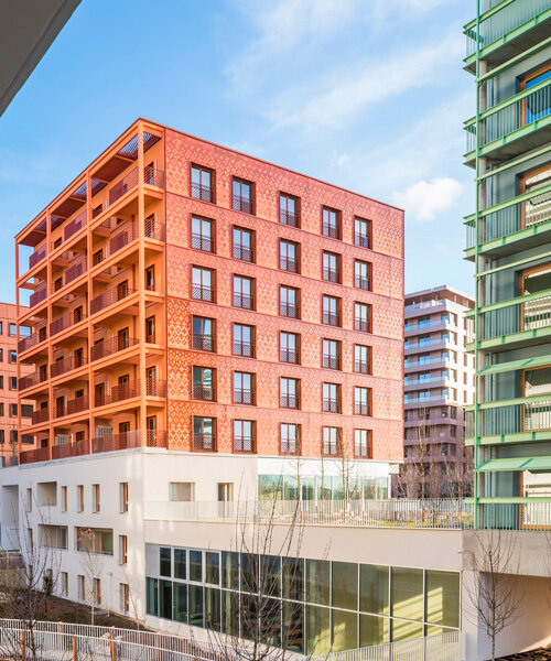 matte terracotta tiles in dynamic patterns outline athletes' village supporting paris olympics