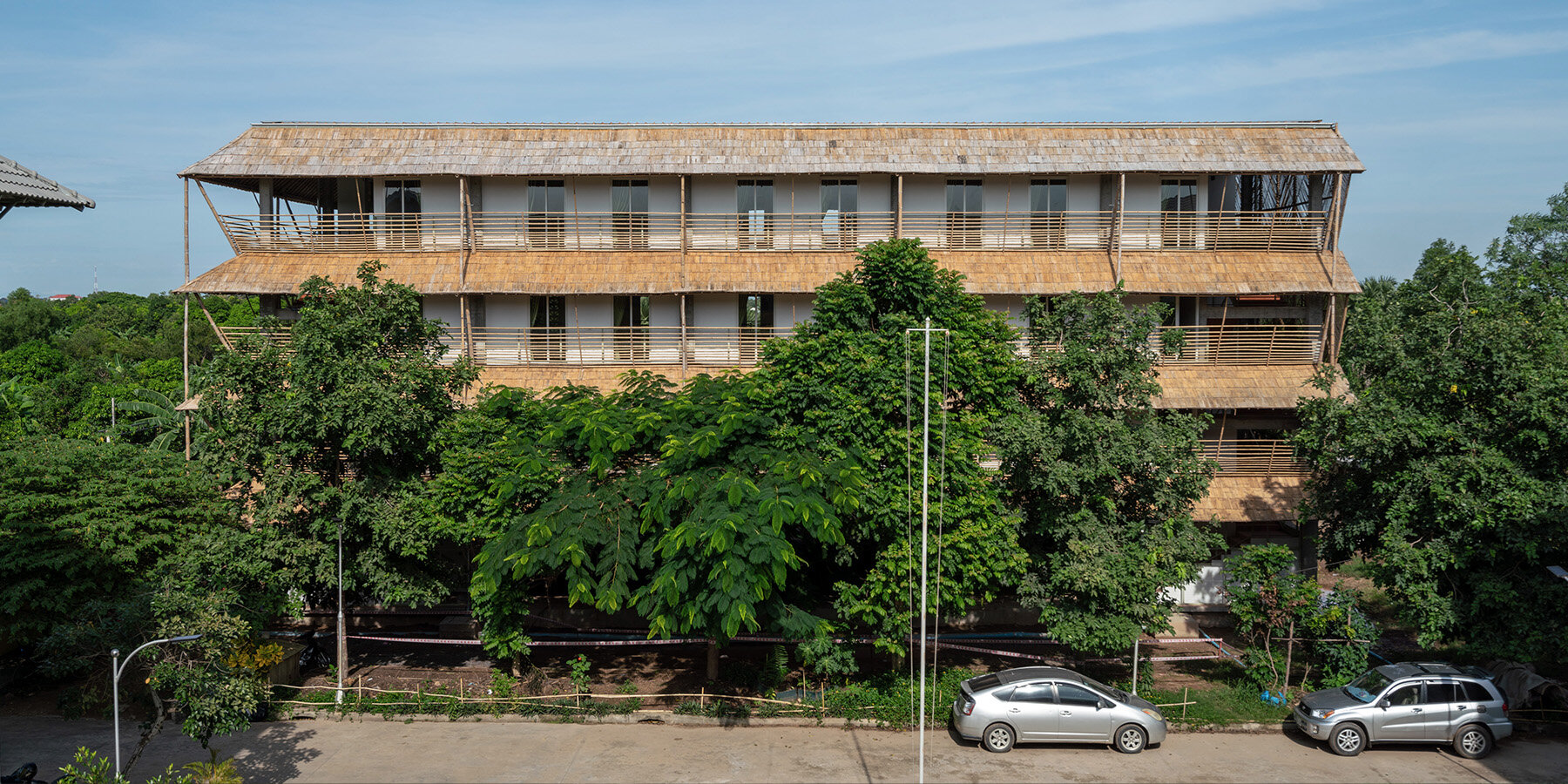 BLOOM screens girl dormitory's concrete skeleton with woven bamboo skin