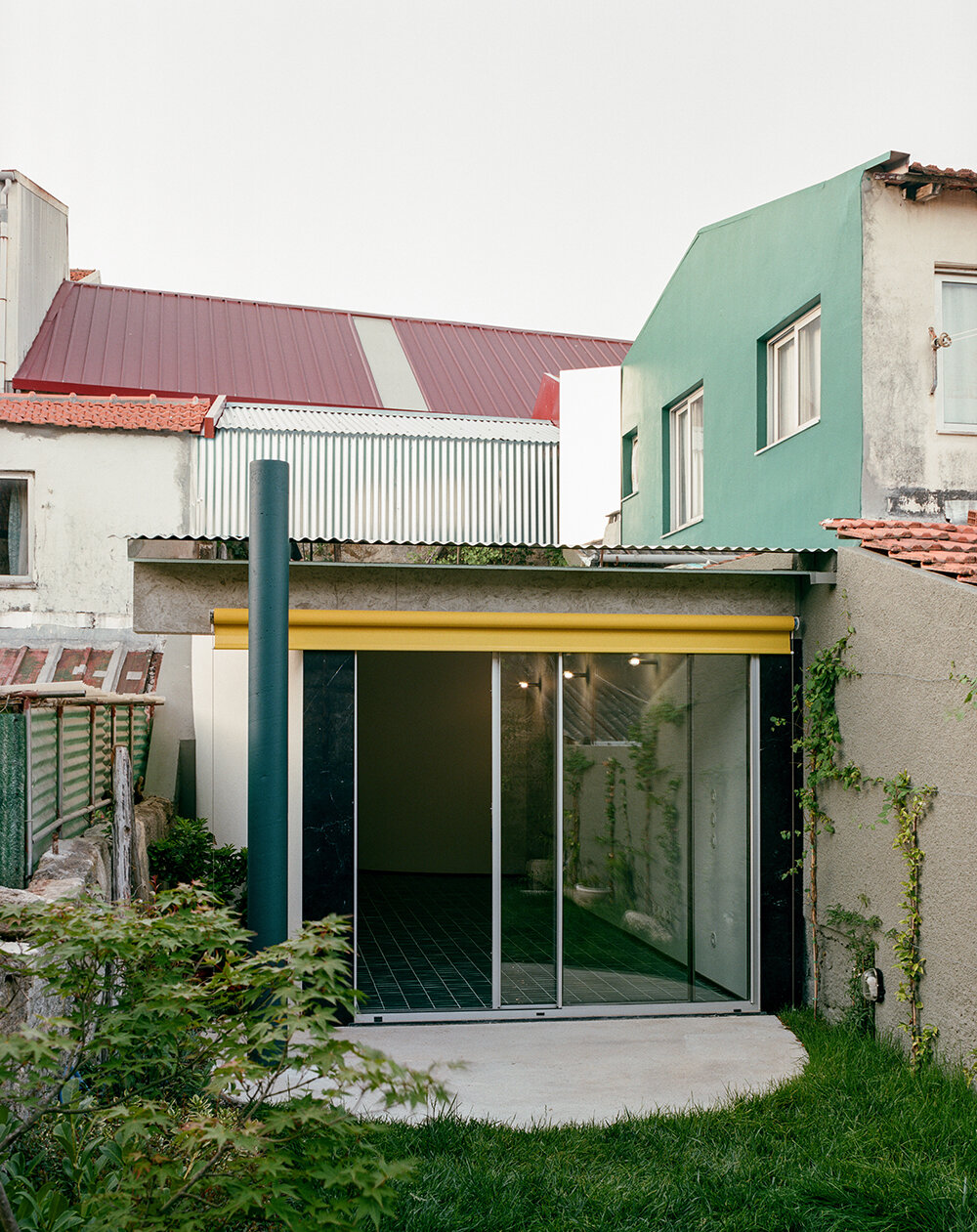 behind a modest front, fala atelier's narrow porto house reveals surprising depth and curves