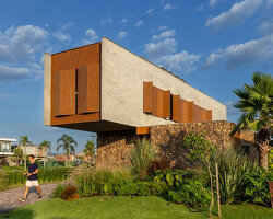 oficina conceito arquitetura's cantilevering house protrudes from stone volume in brazil