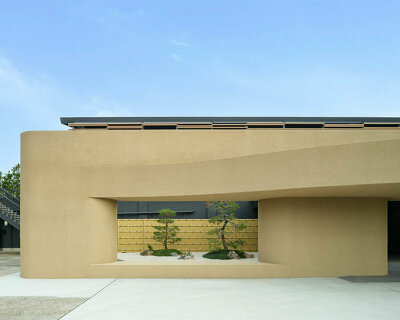 kubo tsushima architects sculpts earthy curved facade for renovated golf club in japan