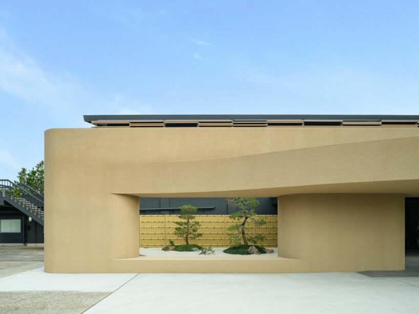 Kubotsushima Architects esculpe una fachada curva y terrosa para la renovación del club de golf japonés