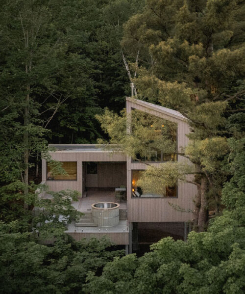 _naturehumaine's pine-wrapped chalet peaks through treetrops of canadian woodlands