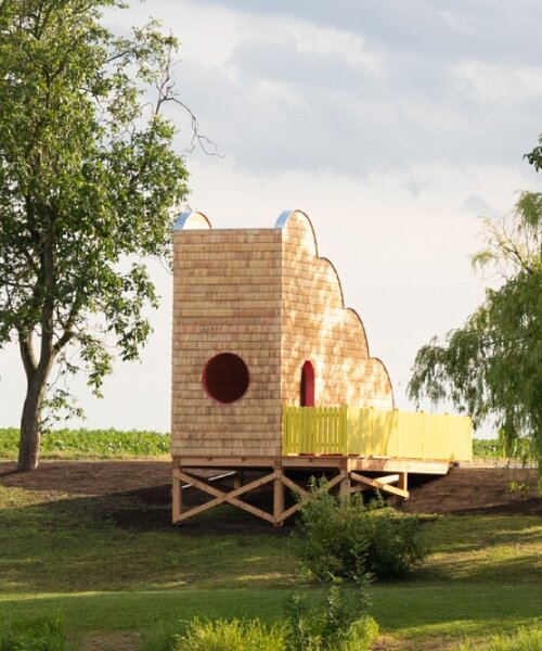 wrapped in wooden shingles, cloud-shaped cyclist shelter ascends to views over iron curtain