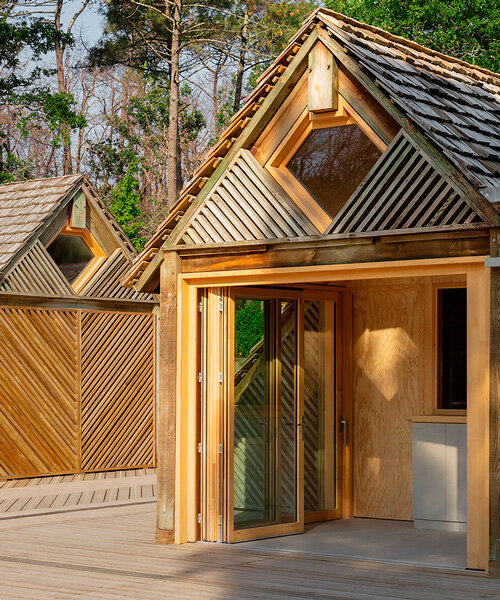 patterned repurposed timber panels clad grande dune du pilat visitor center's huts in france