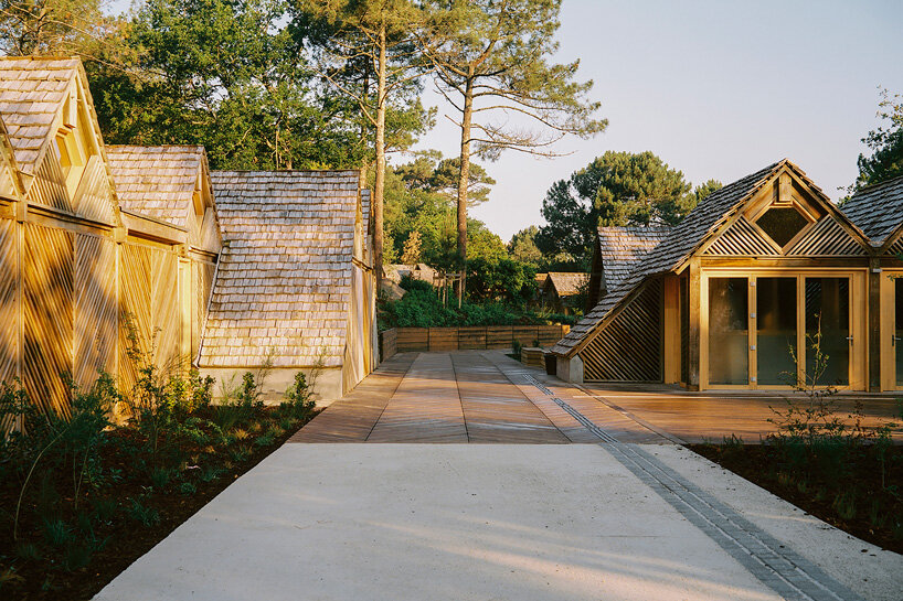 Las cabañas del Centro de Visitantes Great Dune en Pyrrha, Francia, están revestidas con paneles de madera reutilizados con dibujos