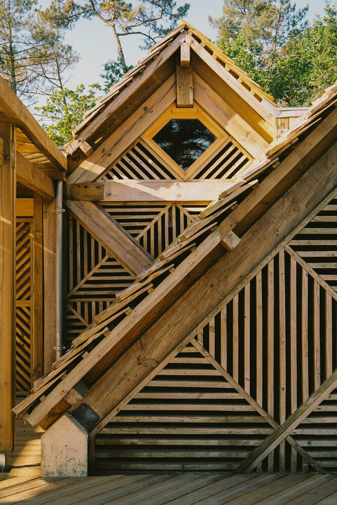 Las cabañas del Centro de Visitantes Great Dune en Pyrrha, Francia, están revestidas con paneles de madera reutilizados con dibujos