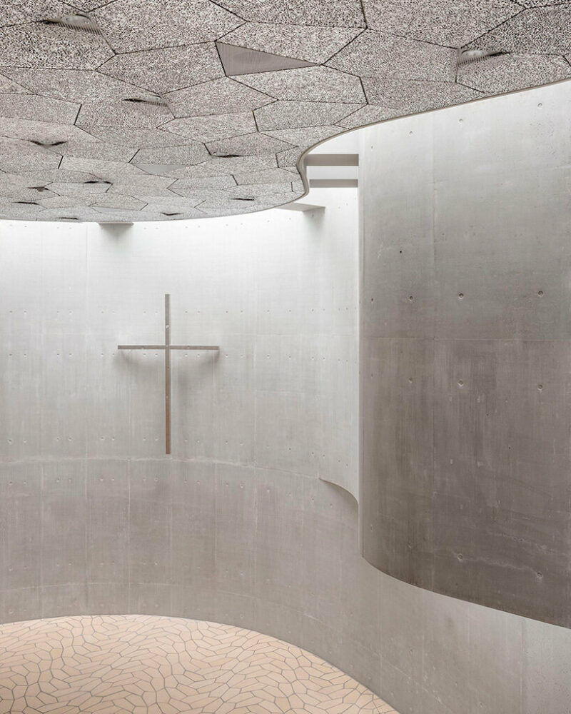 fluid concrete shell wraps timber interiors of danish trekroner church