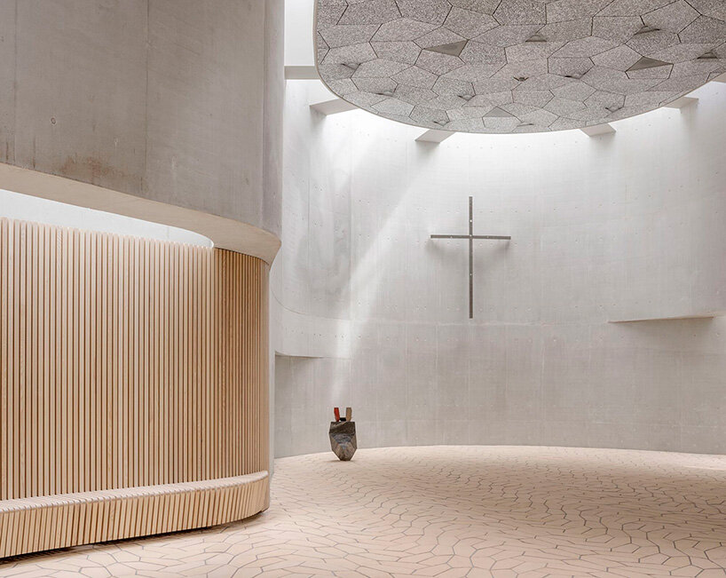 fluid concrete shell wraps warm timber interiors of denmark's trekroner church