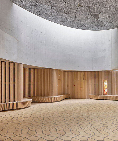 fluid concrete shell wraps warm timber interiors of denmark's trekroner church
